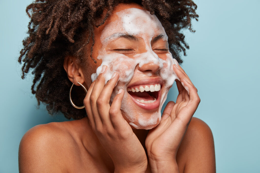 Freepik imagem: Retrato de jovem com corte de cabelo afro lavando a pele