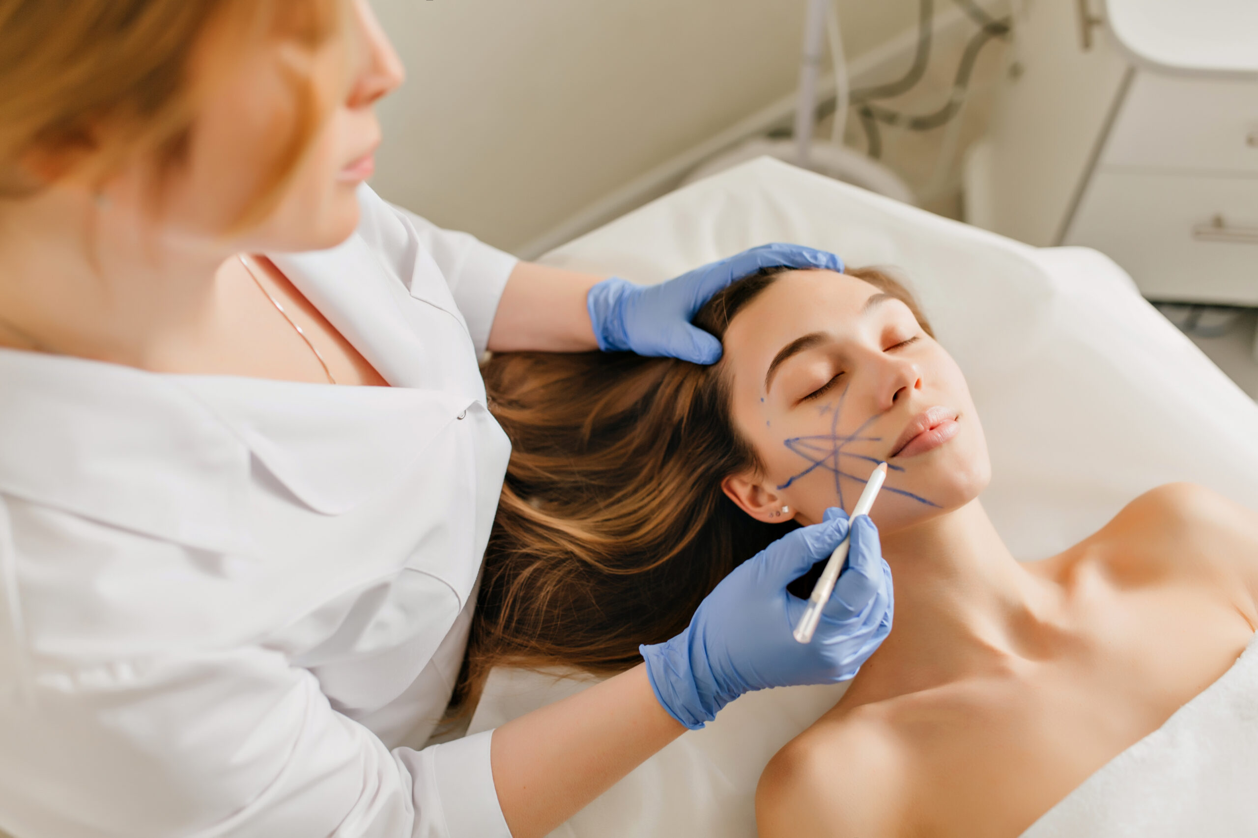 Freepik imagem: mulher com demarcações no rosto para iniciar procedimentos estéticos.