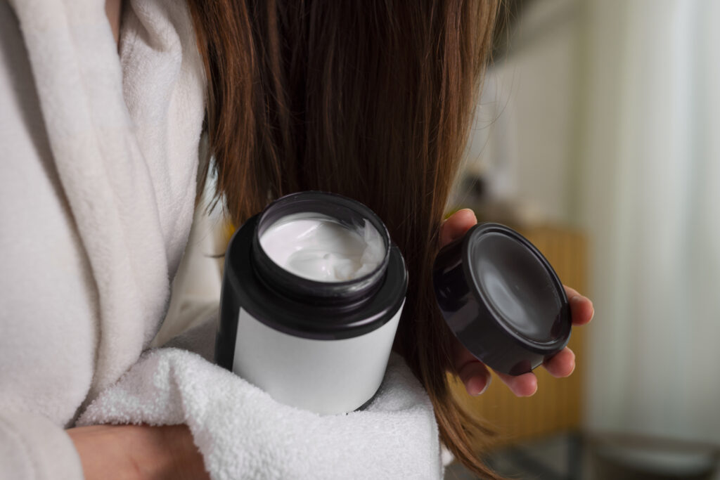 Freepik imagem: Mulher segurando máscara de hidratação capilar.