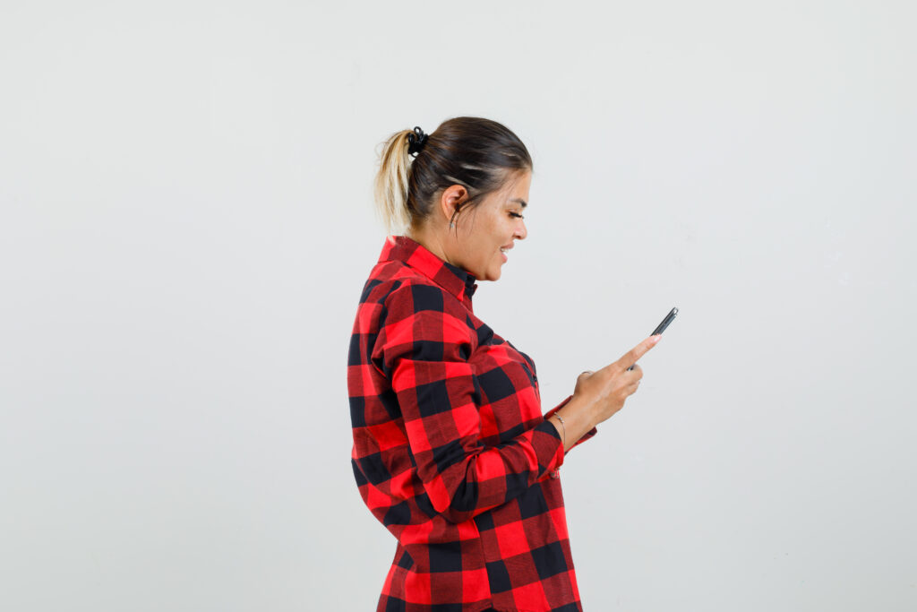 Freepik imagem: mulher com má postura mexendo no celular.