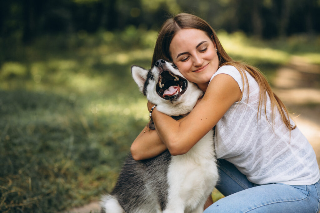 Freepik Imagem: Mulher jovem abraçando seu cachorro.